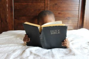 Photo of a child reading a Bible