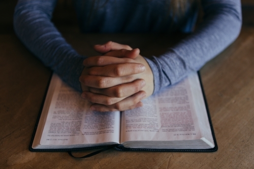 Image of someone prayerfully reading the Bible