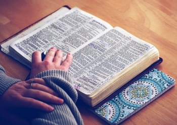 Picture of a person reading a Bible opened to Psalms